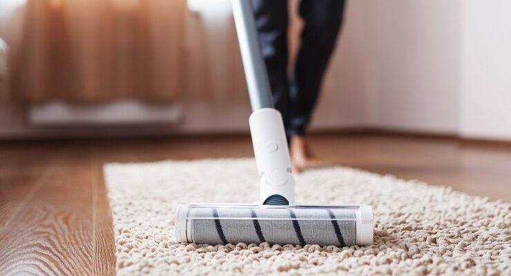 cordless-vacuum-cleaner-cleans-carpet-living-room-with-bottom-legs-modern-technologies-cleaning-house_94046-8292