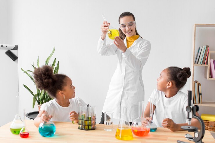 female-scientist-teaching-girls-chemistry-while-holding-tube_23-2148571269