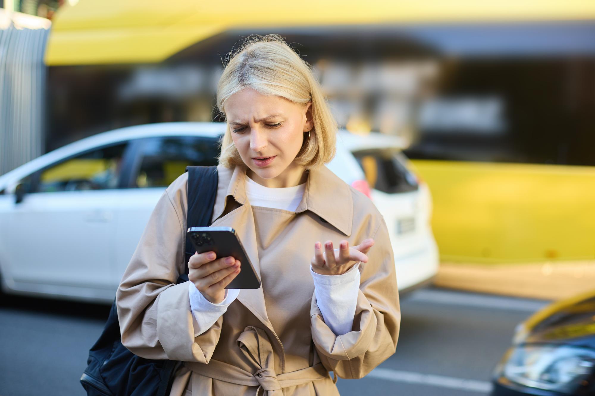 portrait-young-confused-blonde-woman-standing-busy-street-with-cars-her-looking