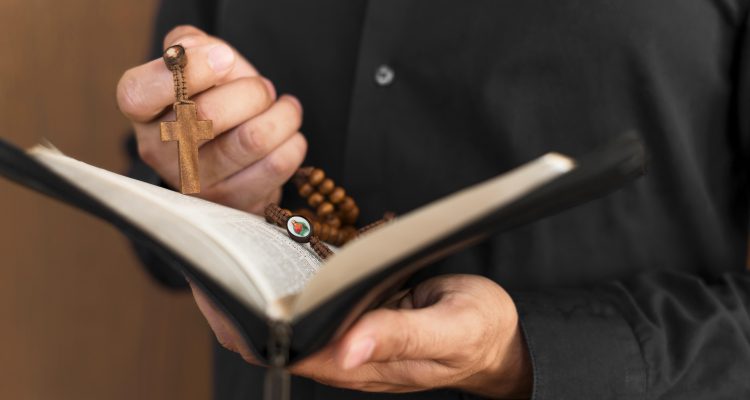 front-view-person-holding-holy-book-rosary