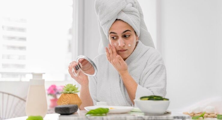 front-view-woman-applying-face-cream_23-2148708051