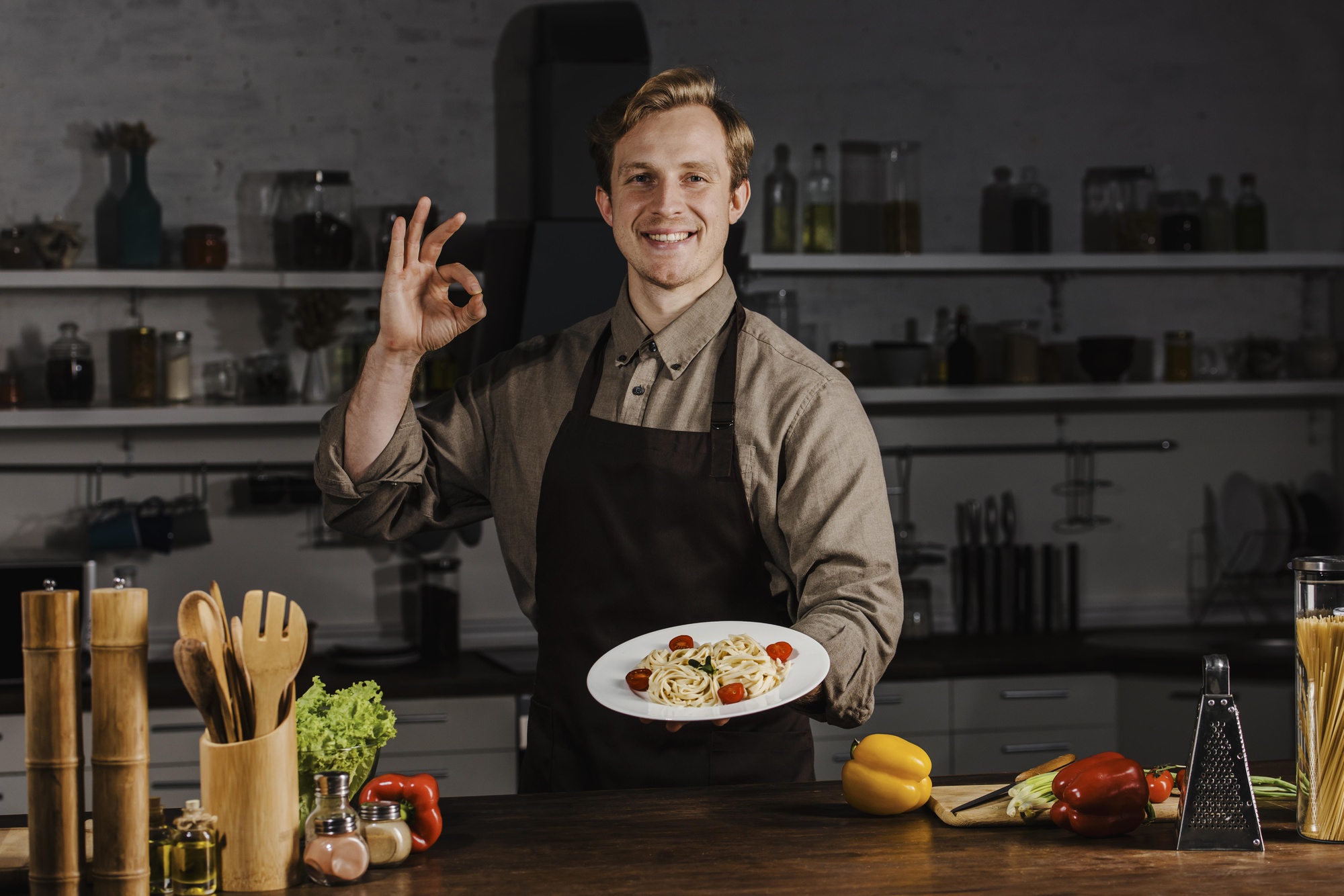 mid-shot-chef-holding-plate-with-pasta-making-ok-sign